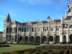The front of the railway station, along with patterned bush gardens.