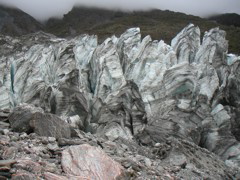 Ice cracks perpendicular to the area of most strain.  In this case, it is bending over a hump in the valley, so the stress along the line of the valley, forming "fingers" visible from the side