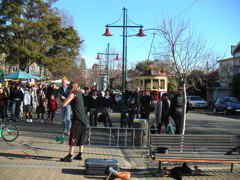 A street performer (although not juggling.. boo), with the historic trolley passing in the background.