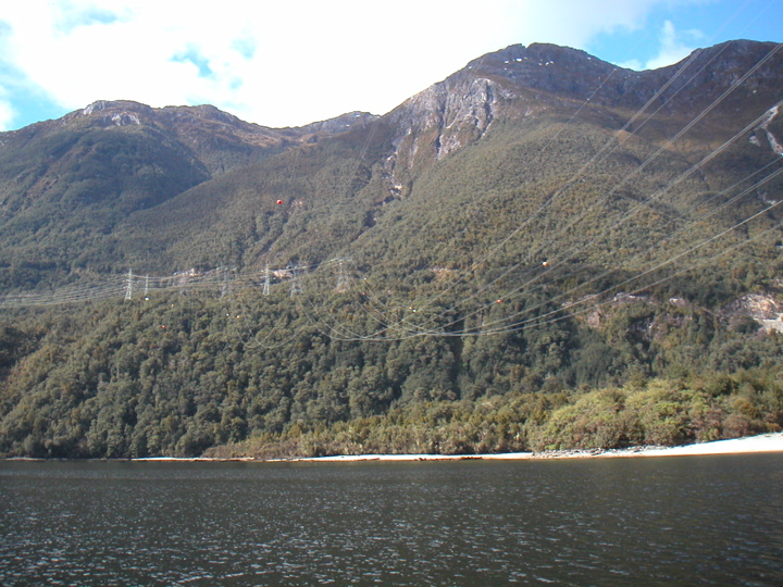 At the far end of Lake Manapouri is a groundbreaking (quite literally) hydro power station which mainly powers an aluminum smelter hundreds of kilometers away.  The power lines seen here stretch over a mile across the lake to start their journey towards the smelter.